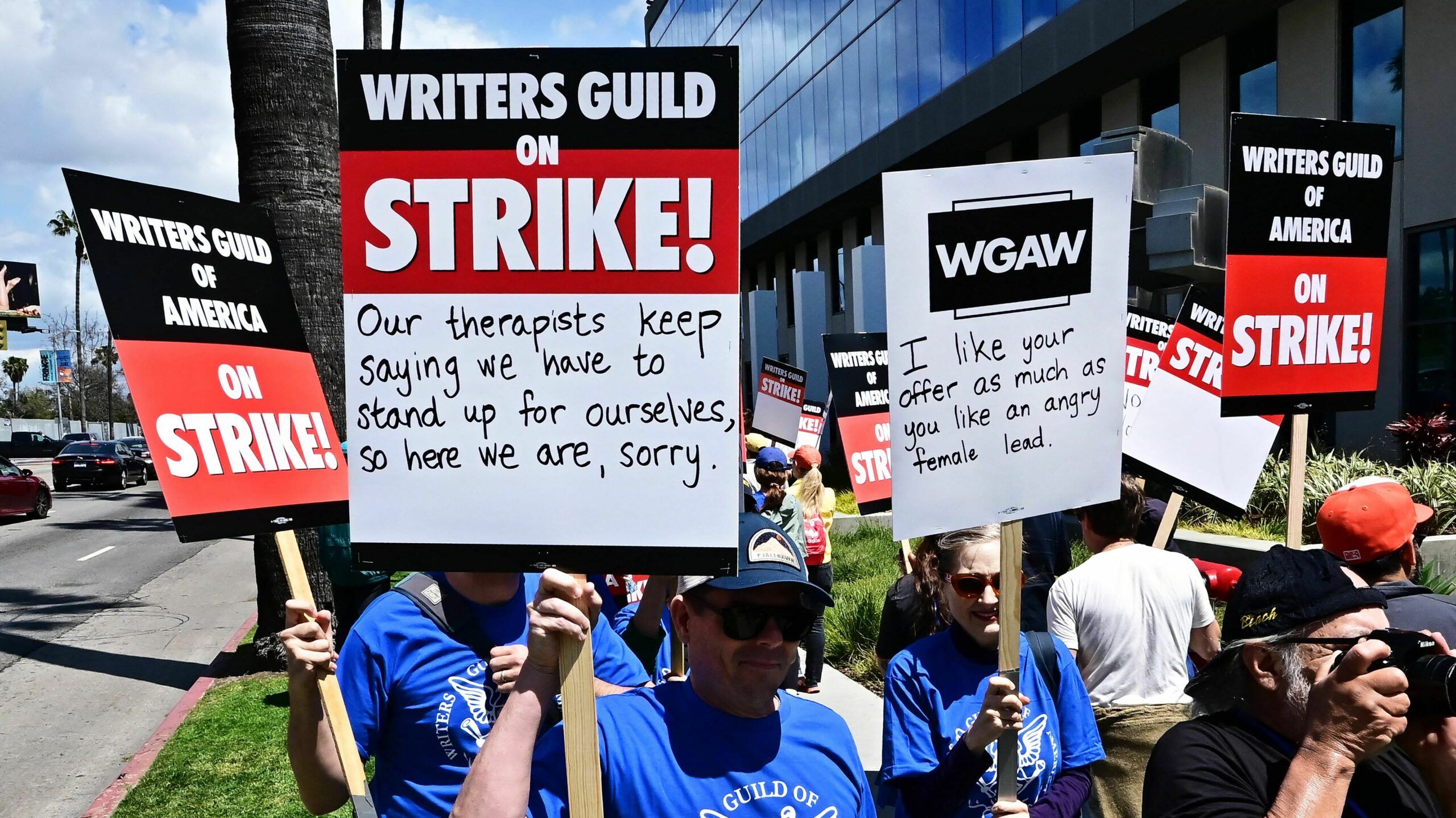 The Best Picket Signs Of The Hollywood Writers&amp;#039; Strike | Wamu throughout Picket House Furnishings Conner 2 Piece Occasional Table Set In Gold Crk1202Pc